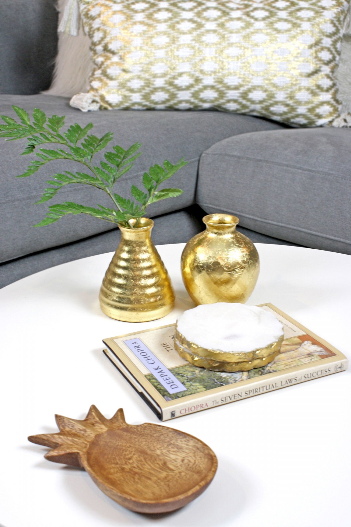 DIY gold leaf vases styled on coffee table with marble coasters and wooden pineapple