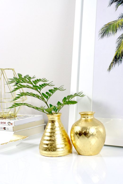 DIY gold leafed vases styled on white credenza with palm tree print
