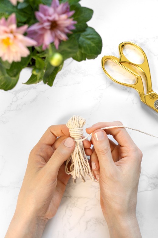 Wrapping cotton string to create a tassel for wood bead garland