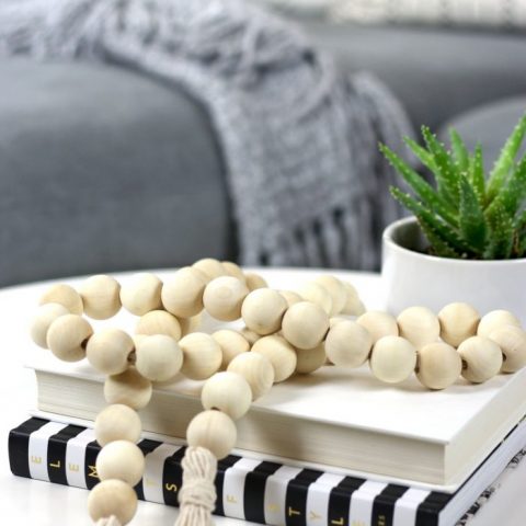 Close up of DIY bohemian wood bead garland styled on IKEA coffee table