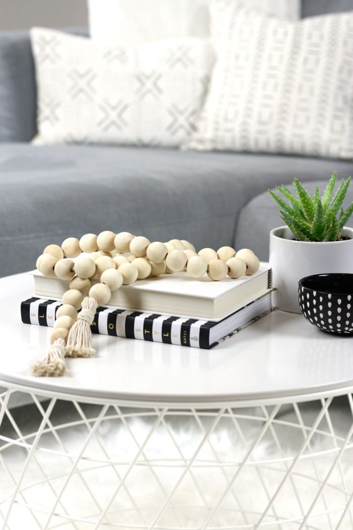 DIY wood bead garland styled on coffee table with mudcloth pillows in background