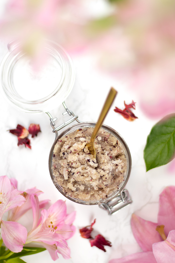 View from above of hibiscus and ylang-ylang sugar scrub in glass jar