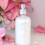 DIY shimmer setting spray in front of pink flowers