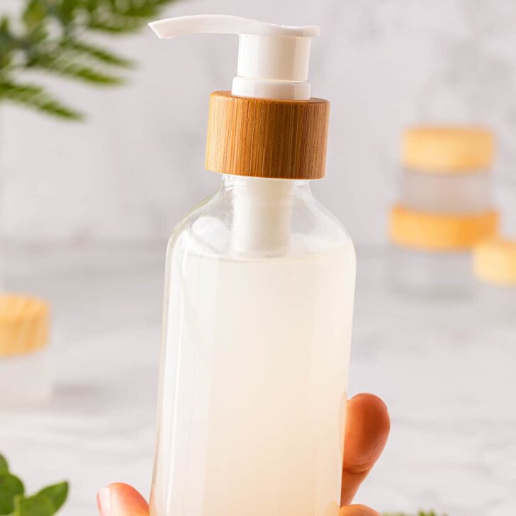 DIY cleansing oil makeup remover held in woman's hand.