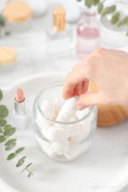 Grabbing homemade face cleansing wipe from glass jar