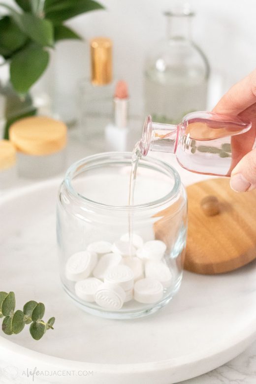 Pouring DIY makeup remover into jar filled with wipes