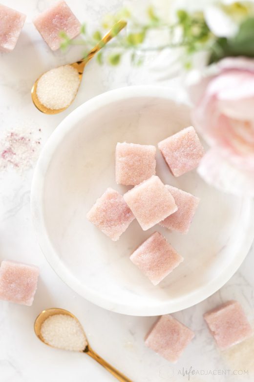 Pink rose sugar scrub cubes on marble plate