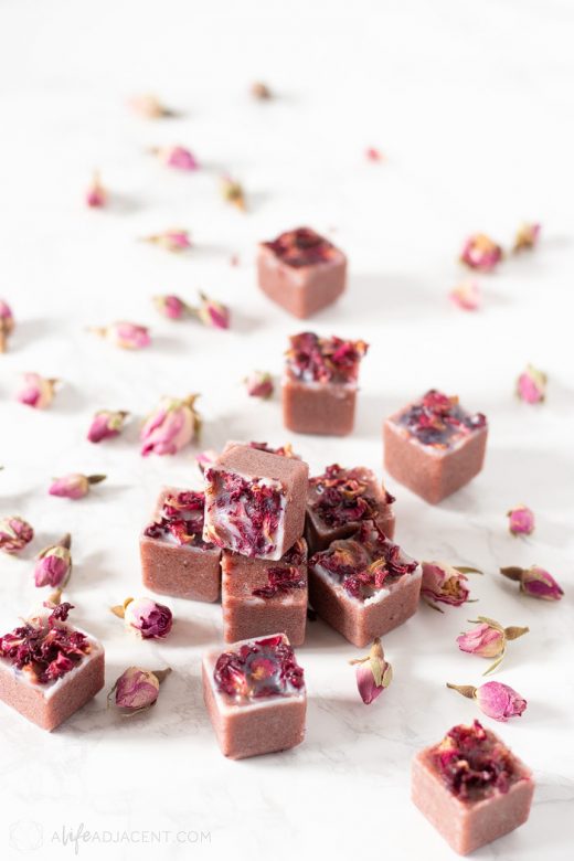 Pile of homemade sugar scrub cubes with pink rose petals