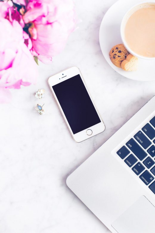 Cell phone on desk with laptop