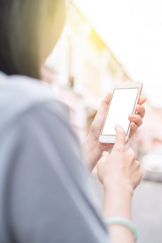 Girl using mobile phone in bright sunlight