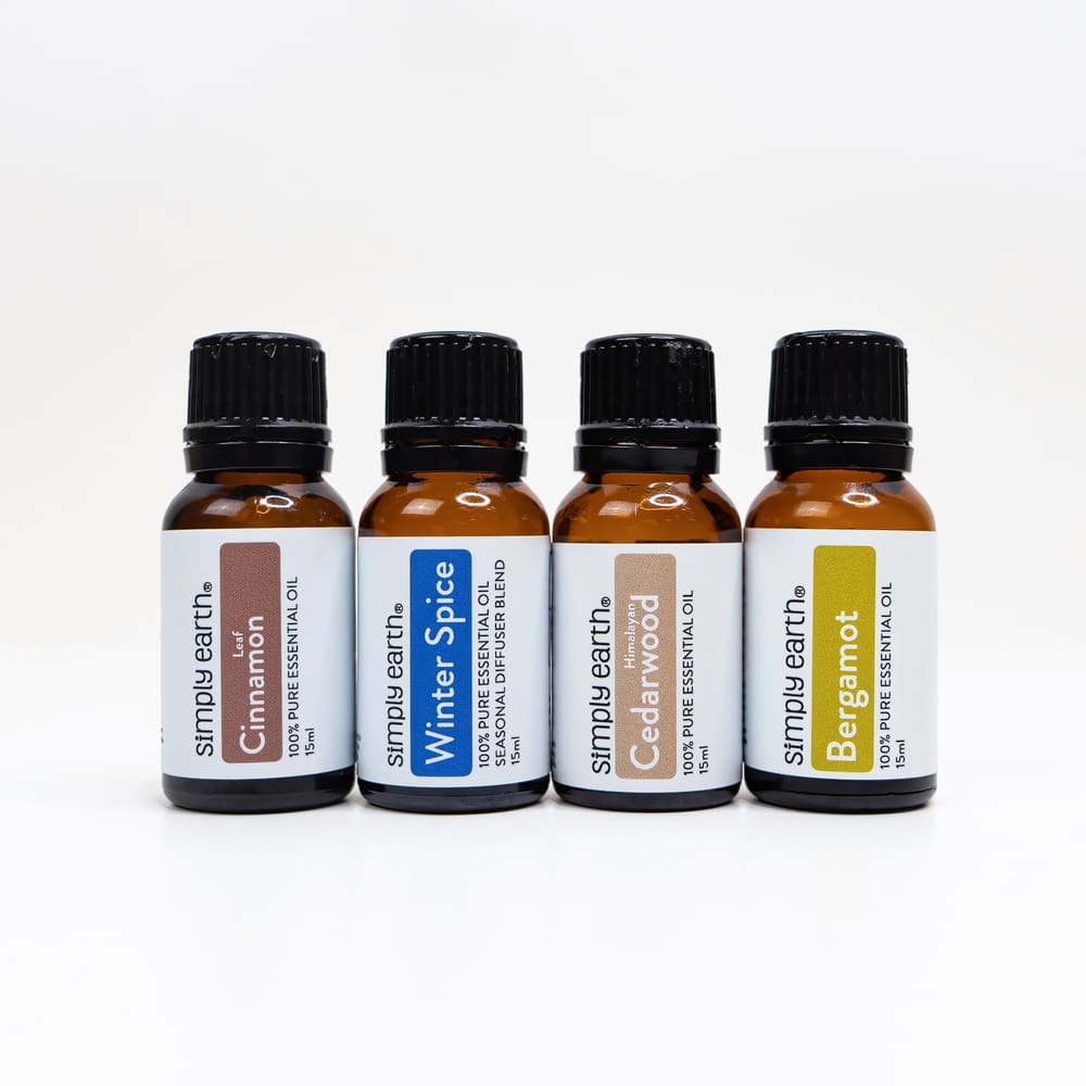 Bottles of Simply Earth essential oils for making homemade Christmas soap. From left to right: cinnamon leaf, winter spice, Himalayan cedarwood and bergamot