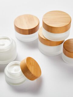 Containers for homemade skincare – glass cosmetic jars with bamboo lids.