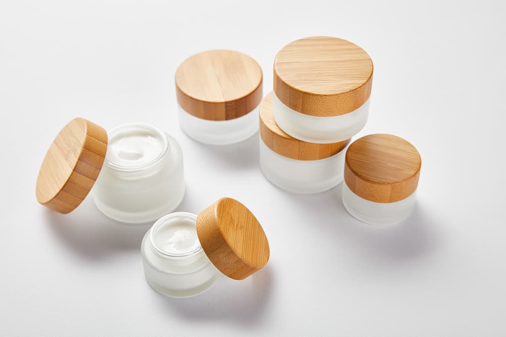 Containers for homemade skincare – glass cosmetic jars with bamboo lids.