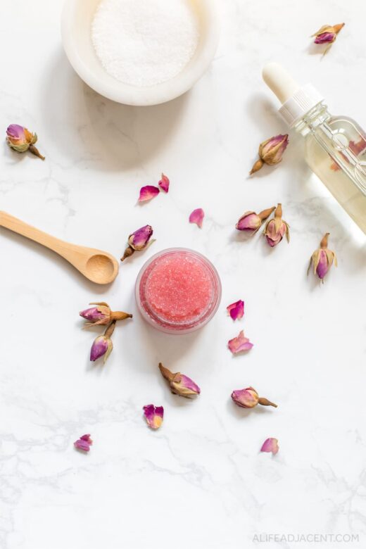 Homemade rose sugar lip scrub with rose petals and coconut oil.