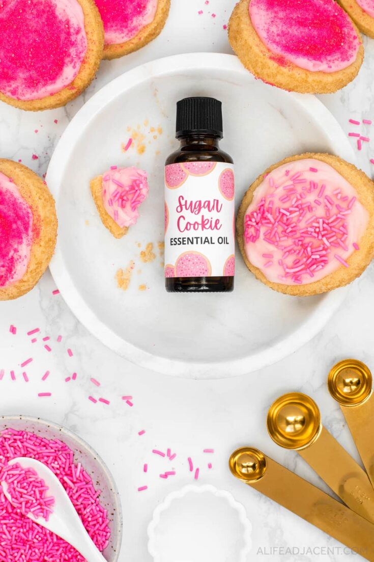 Sugar cookie fragrance oil with essential oils pictured on white marble plate.