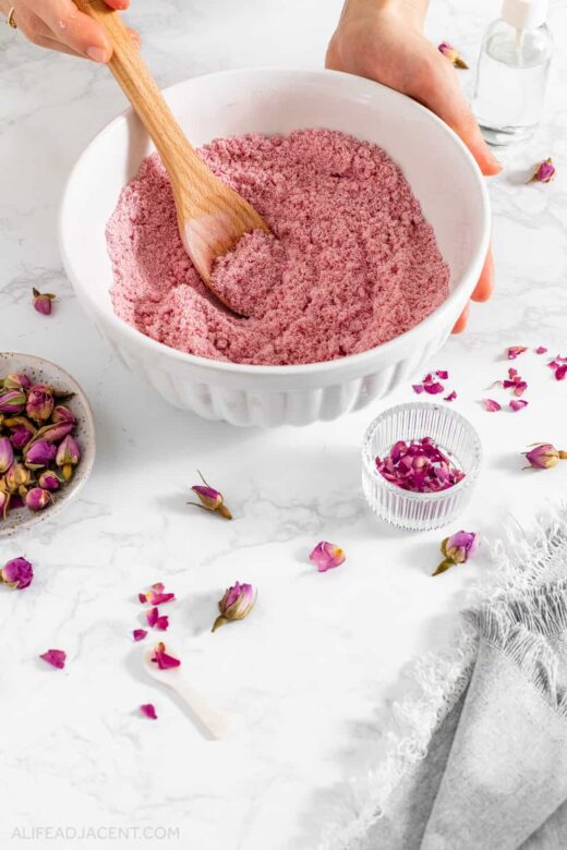 Mixing cocoa butter into pink rose bath bombs mixture