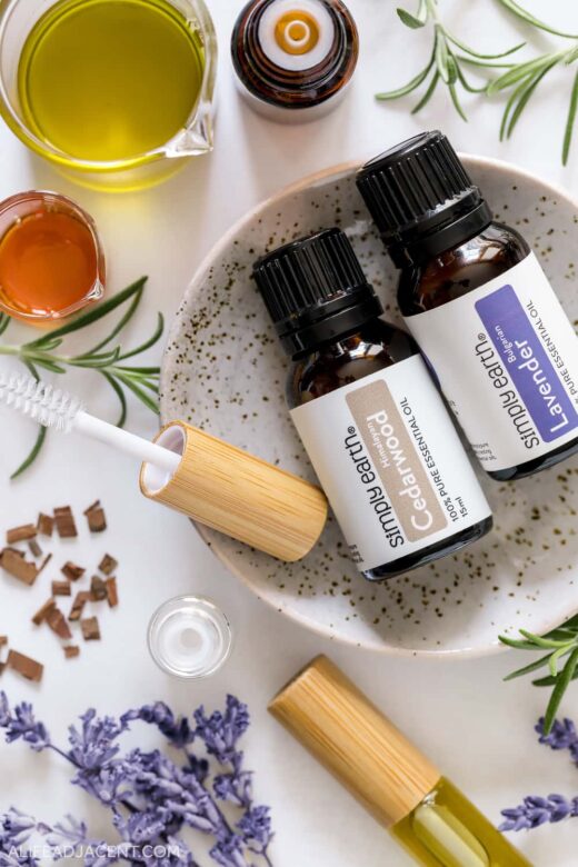 Natural ingredients for DIY brow serum. Green tea infused castor oil and vitamin E with lavender, rosemary, and cedarwood essential oils for eyebrow growth.
