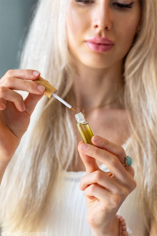 Woman holding homemade lash serum for growth