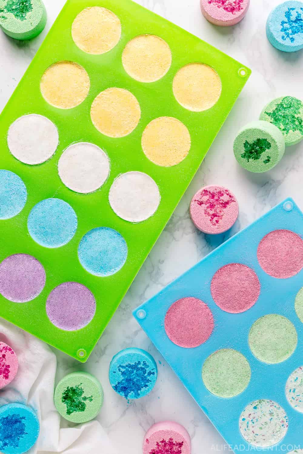 DIY shower steamers drying in silicone tablet molds.