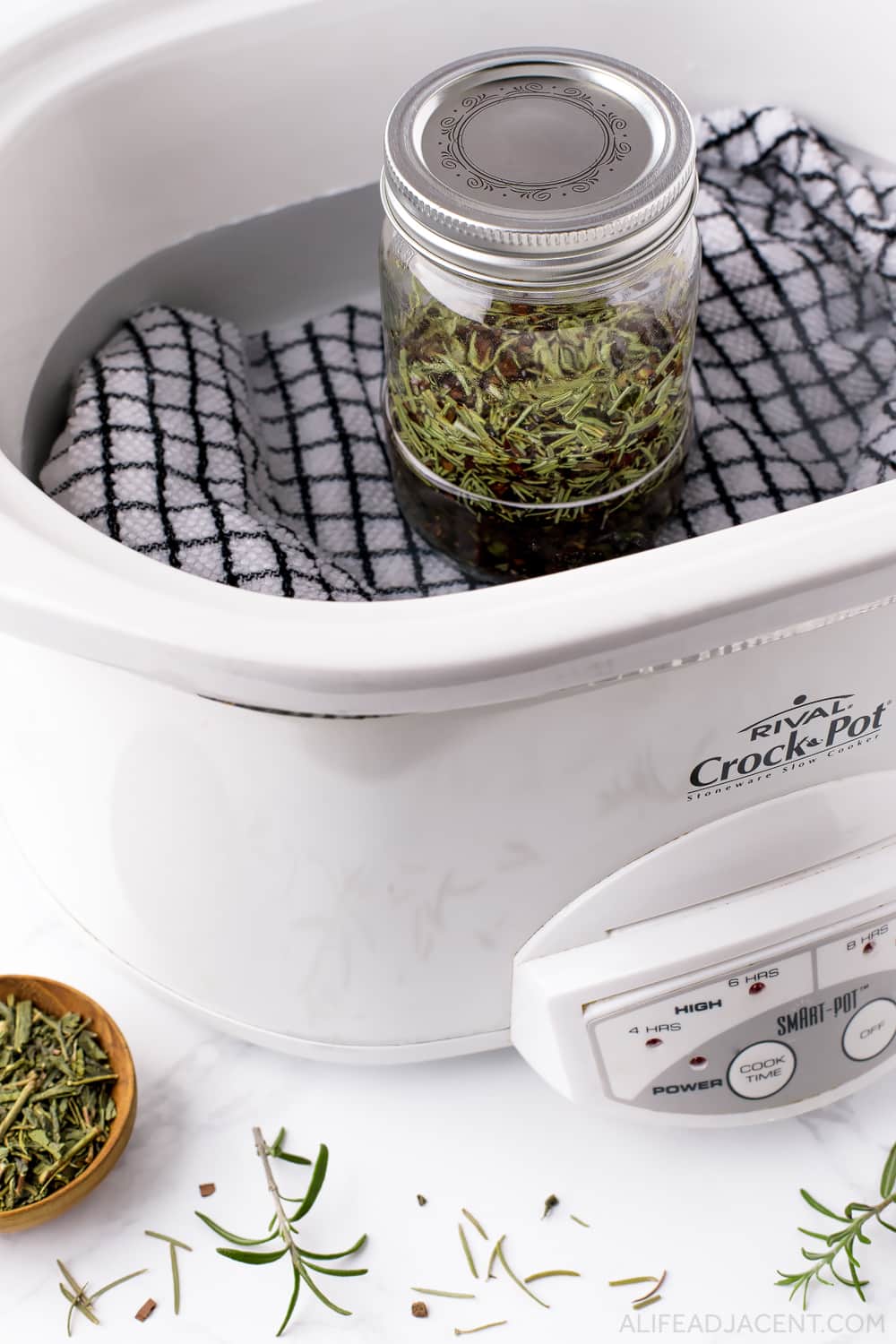 Placing herbal infused hair oil in slow cooker for infusion.