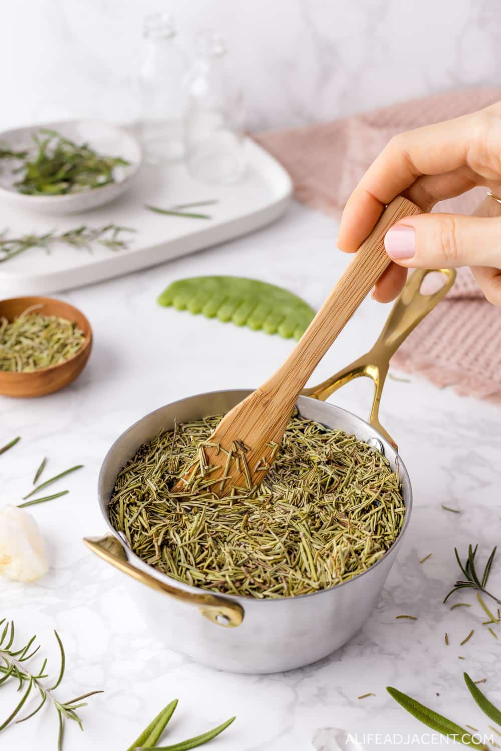 How to make rosemary water for hair &ndash; mixing rosemary leaves and distilled water in pot.