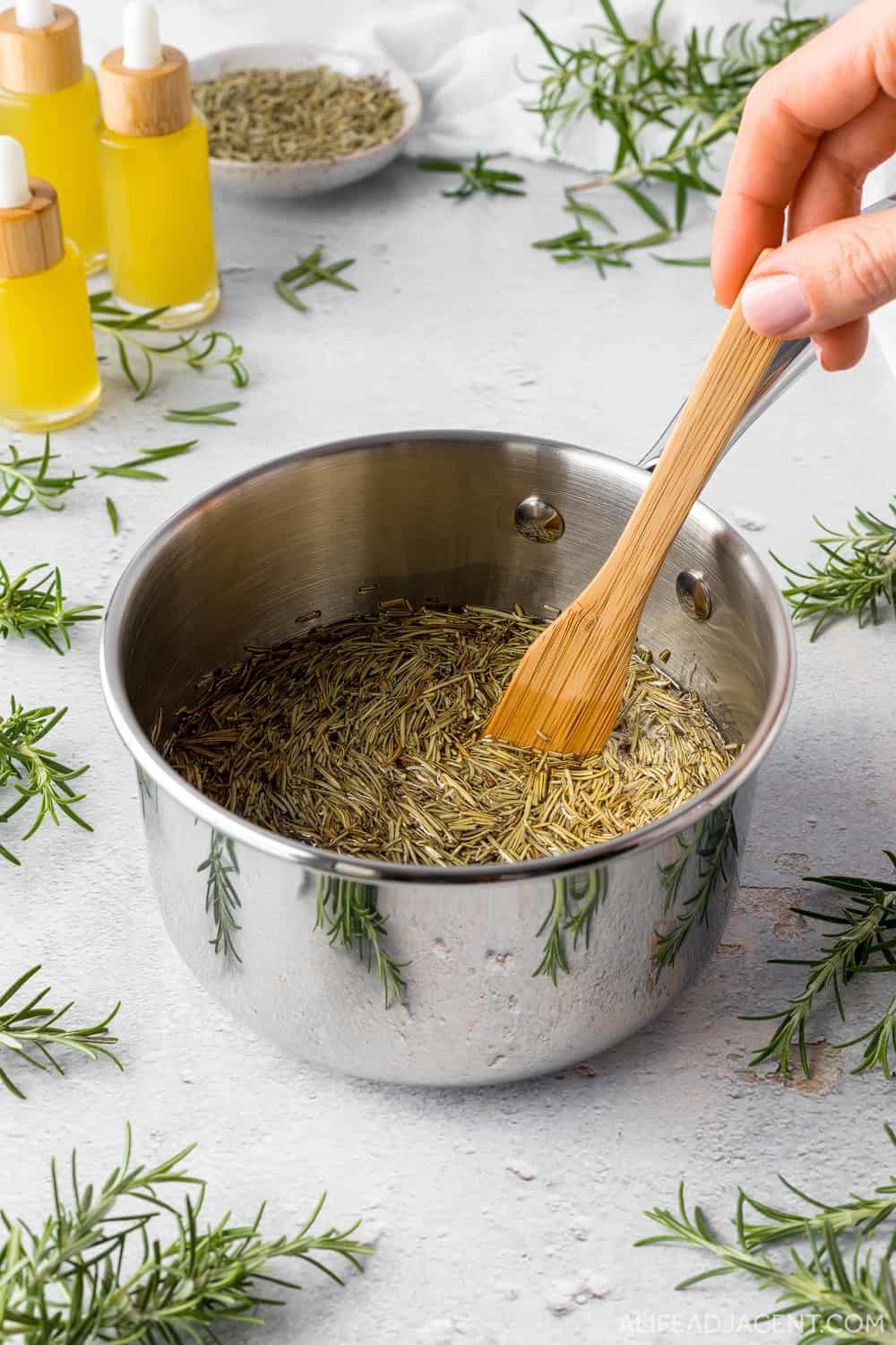 Stirring pot filled with rosemary mixture.