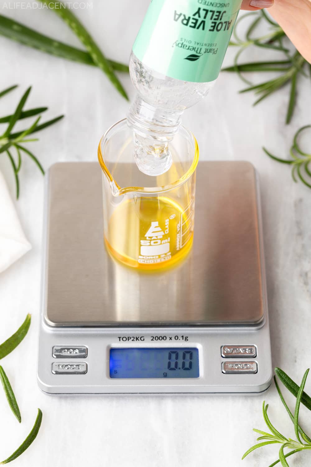 Adding aloe vera gel to hair growth mixture.