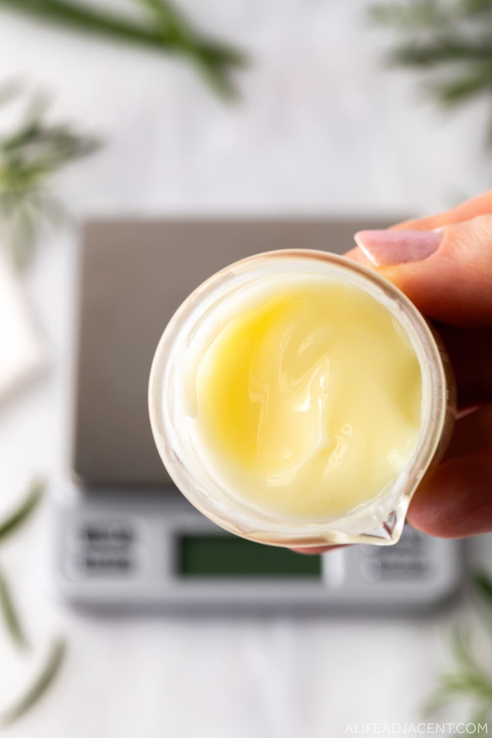 DIY hair growth serum in glass beaker emulsified into creamy, moisturizing gel.