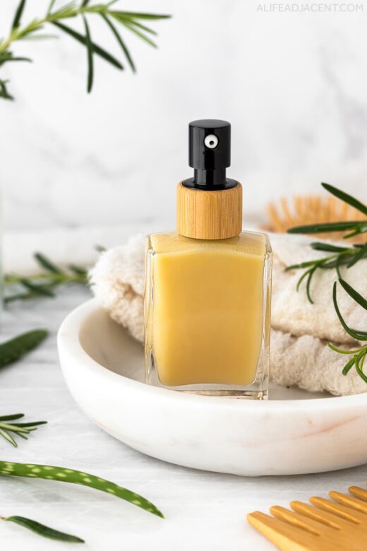 Rosemary oil serum for hair on marble plate.