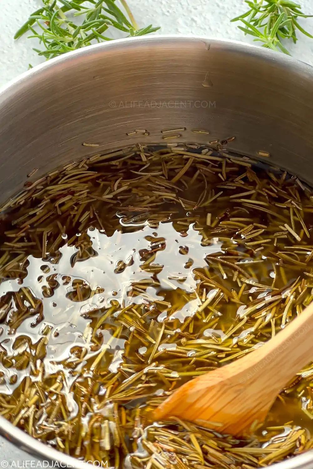Rosemary hair oil infusing in pot.