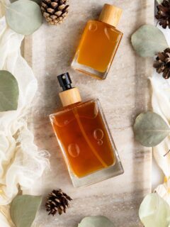 DIY body spray with essential oils in glass cologne bottles, featuring a woody fragrance for men.