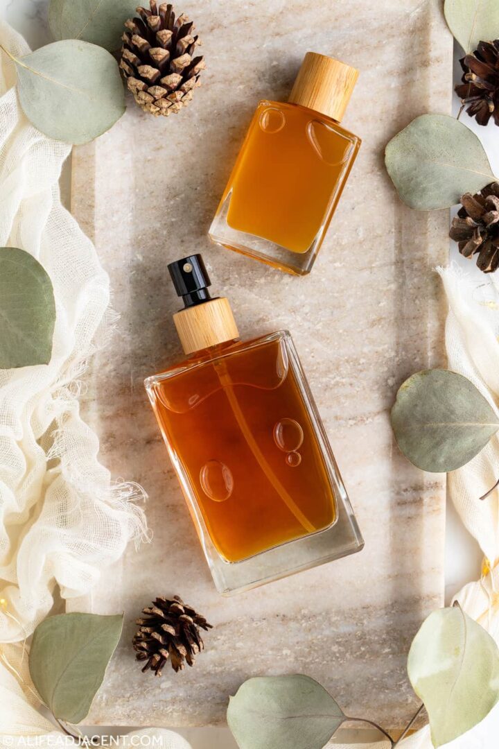 DIY body spray with essential oils in glass cologne bottles, featuring a woody fragrance for men.
