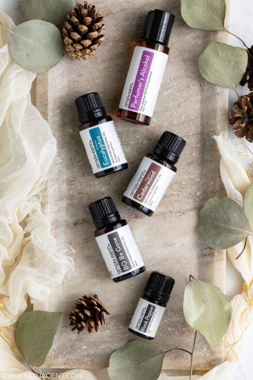 Ingredients for a natural men's body spray recipe, including perfumer's alcohol and cedarwood, black pepper, and eucalyptus essential oils.